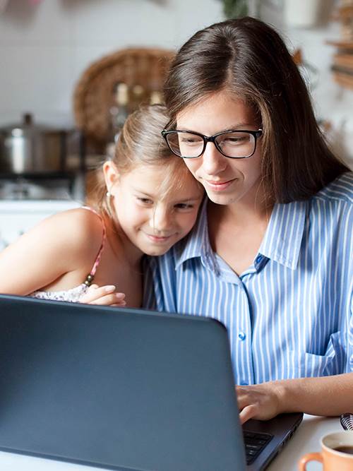 sweet mother and daughter looking at accounts for kids on laptop
